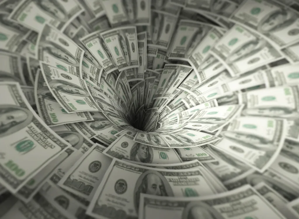 Hundred-dollar bills swirling into a vortex symbolizing a small business cash flow crunch